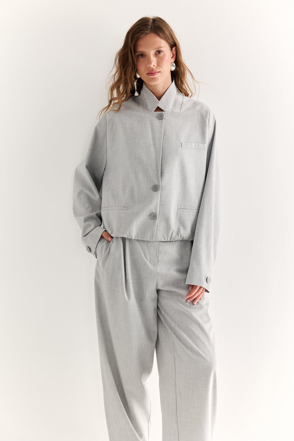 Woman wearing a light gray suit on a white background