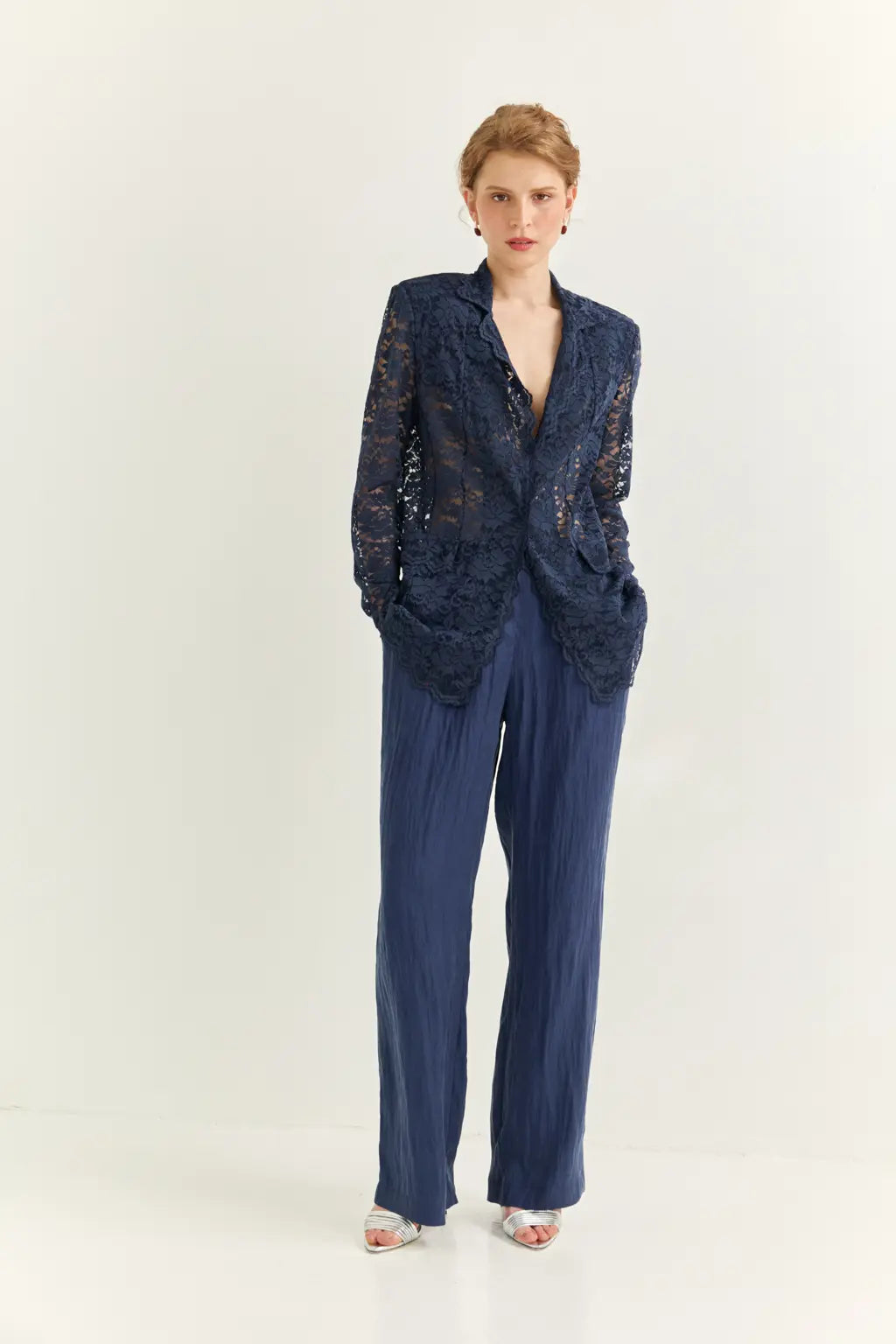 Ayra Store based in New York united states of America Woman wearing AYRA Vinyl Corded Lace Jacket with notched lapel and scalloped hem paired with fluid navy blue trousers