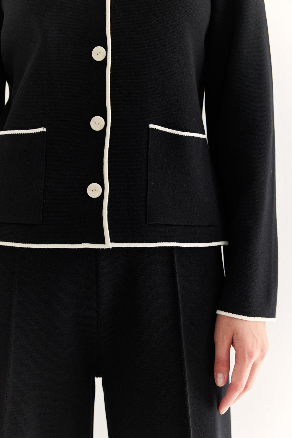 Black suit jacket with white trim on a white background