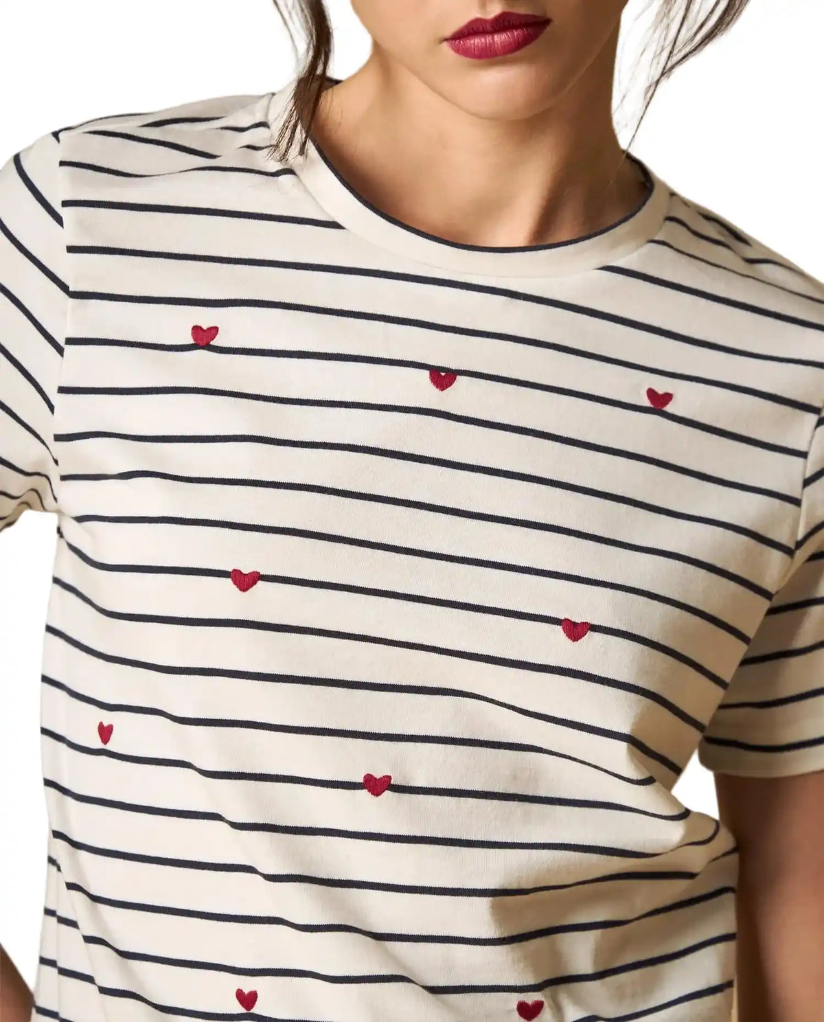 Woman wearing AYRA off-white and navy striped short-sleeved t-shirt with delicate red heart embroidery