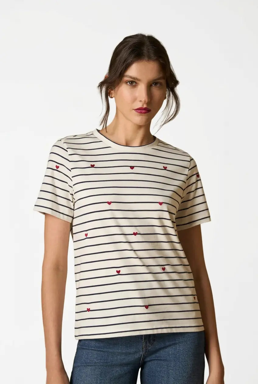 Woman wearing AYRA off-white and navy striped short-sleeved t-shirt with delicate red heart embroidery