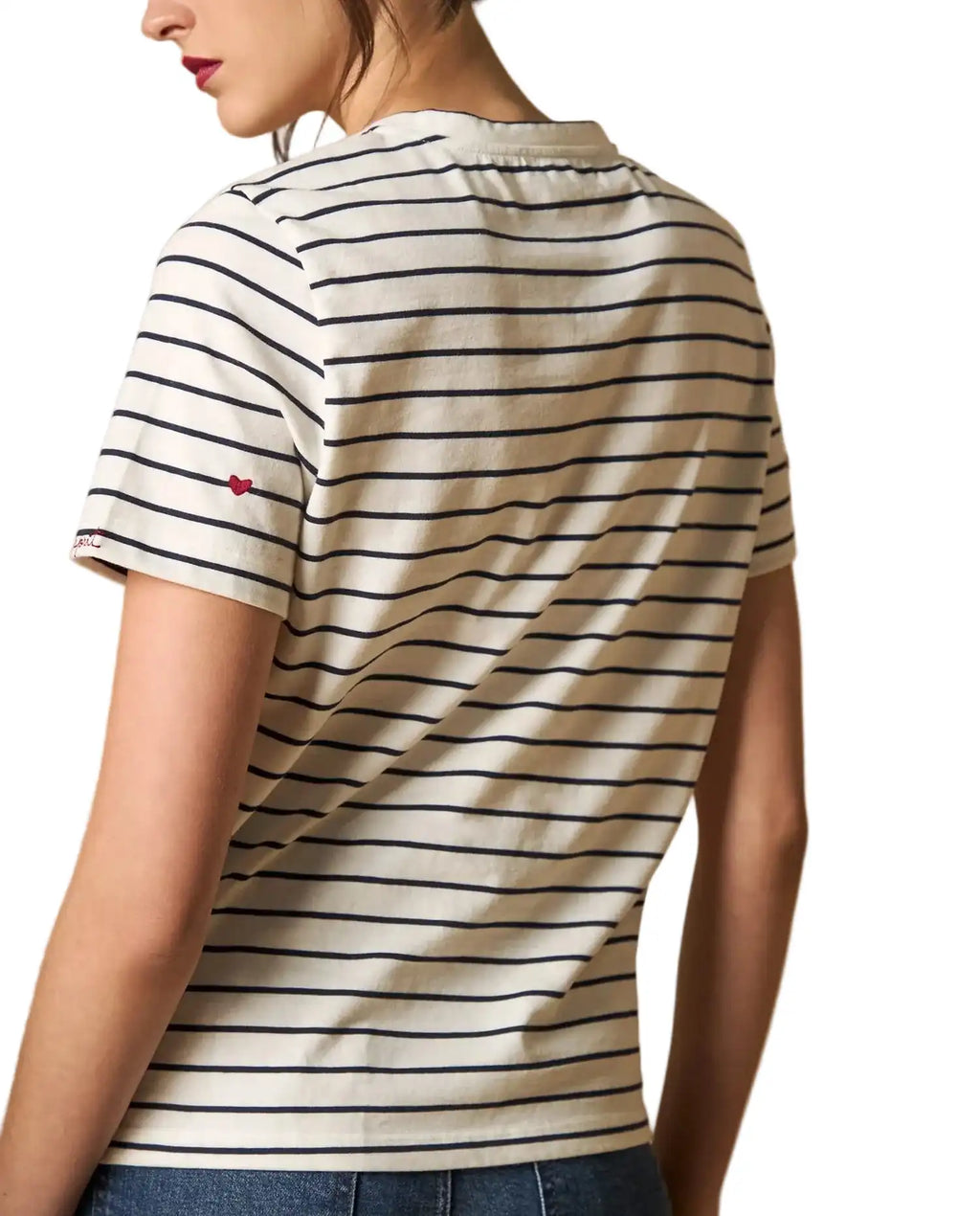 Woman wearing AYRA off-white and navy striped short-sleeved t-shirt with delicate red heart embroidery