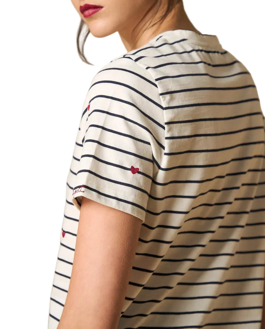 Woman wearing AYRA off-white and navy striped short-sleeved t-shirt with delicate red heart embroidery