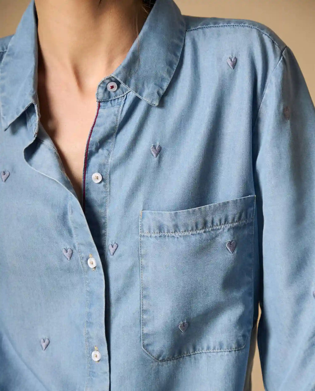 Woman wearing AYRA blue embroidered long-sleeved denim shirt with classic collar and subtle motif detailing   