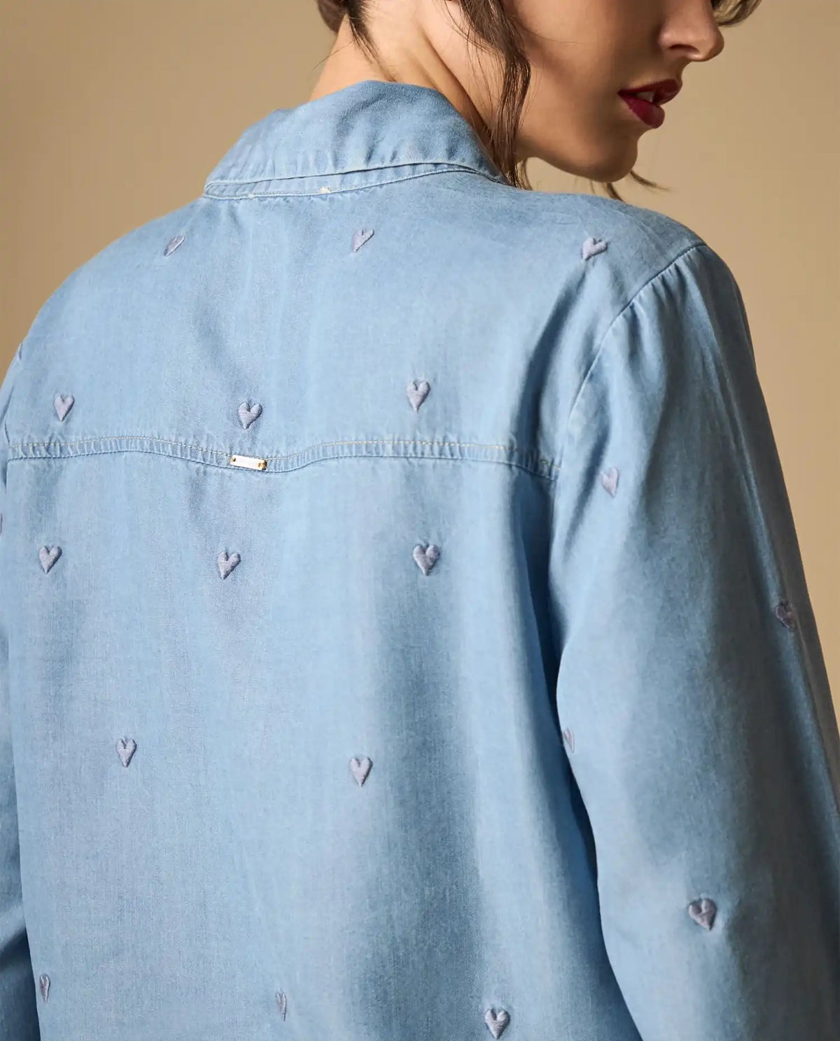 Woman wearing AYRA blue embroidered long-sleeved denim shirt with classic collar and subtle motif detailing   