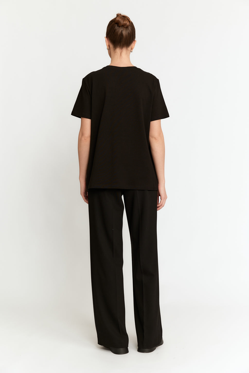 Person wearing a black outfit on a white background