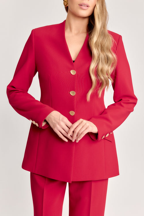 Red suit with gold buttons worn by a model on a light gray background