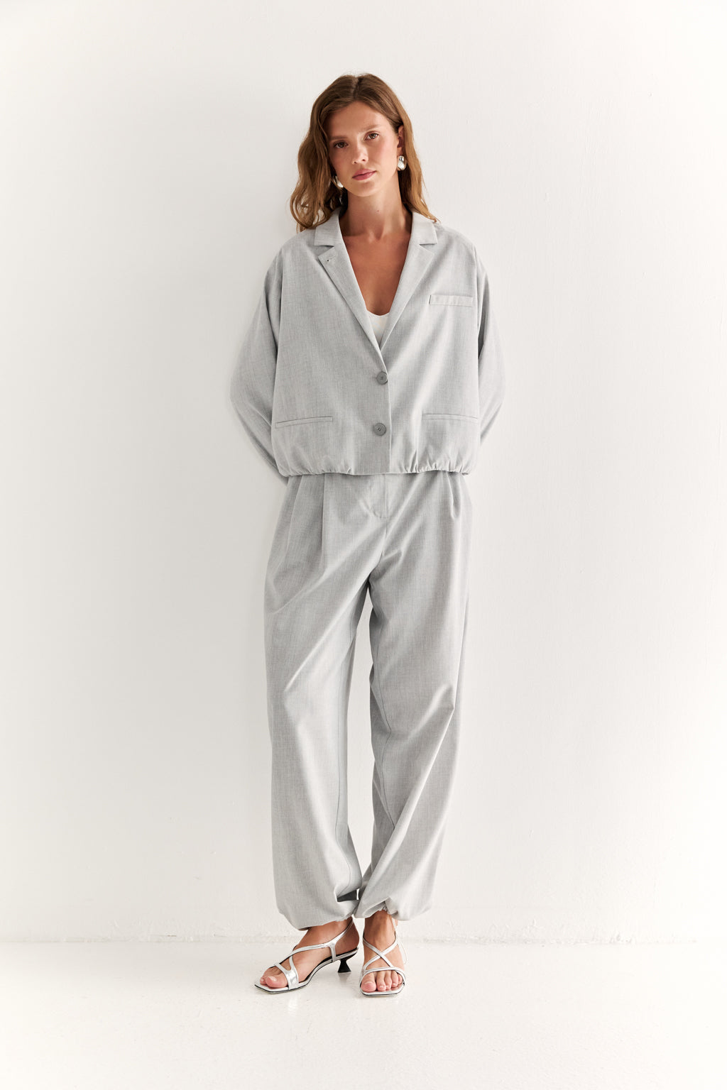 Woman wearing a light gray outfit on a white background