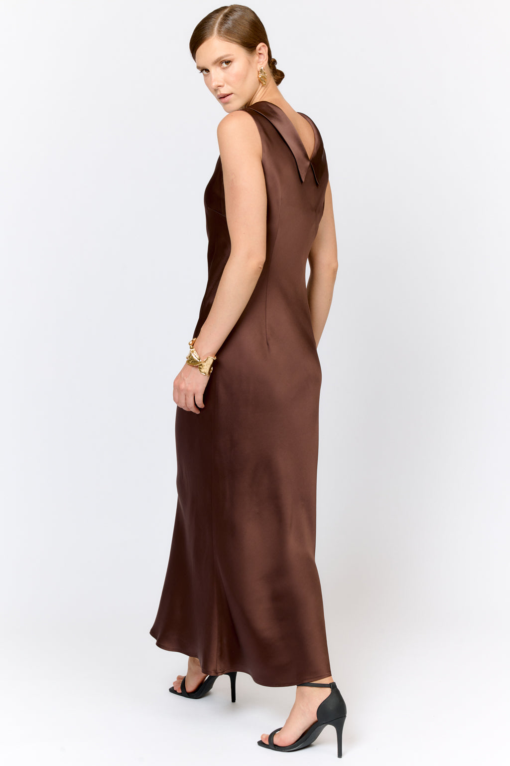 Woman wearing a brown evening gown on a white background