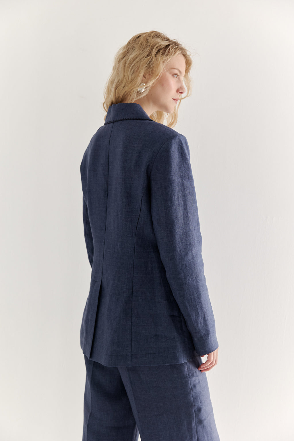 Woman wearing a blue suit against a white background