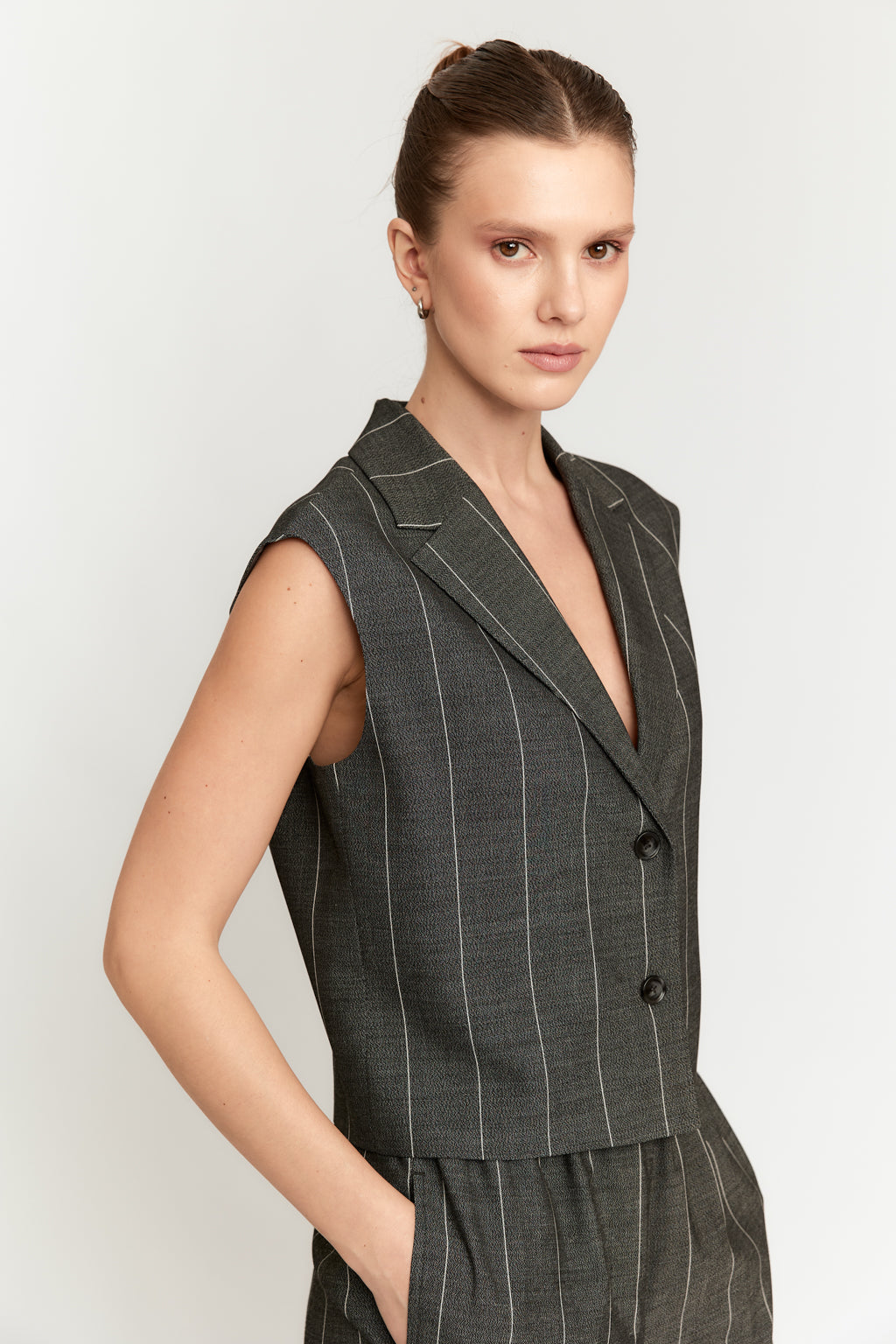 Woman wearing a gray pinstripe suit on a white background