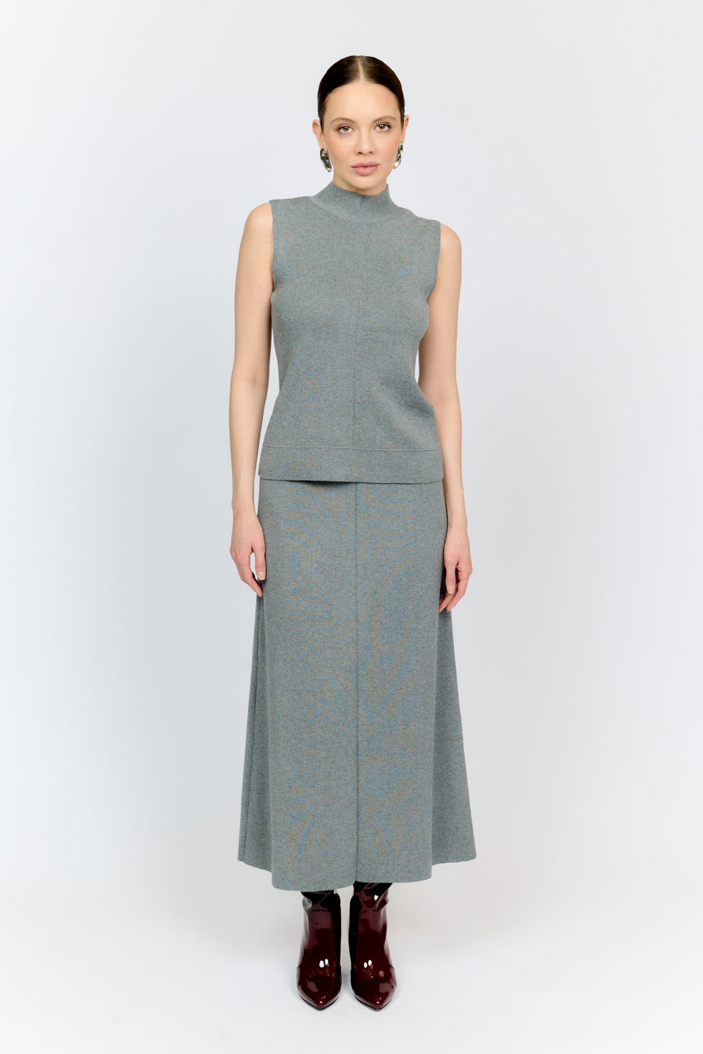 Woman wearing a gray sleeveless top and skirt set on a white background