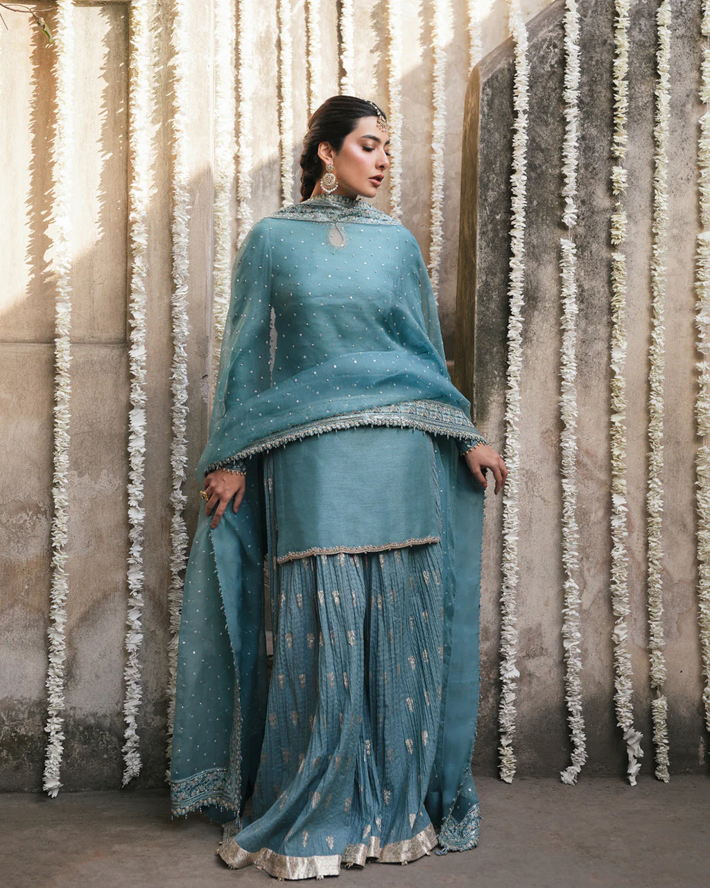 tisha-regal-turquoise-sharara-set-with-scalloped-embroidered-dupatta-borders-standing-view-ayra