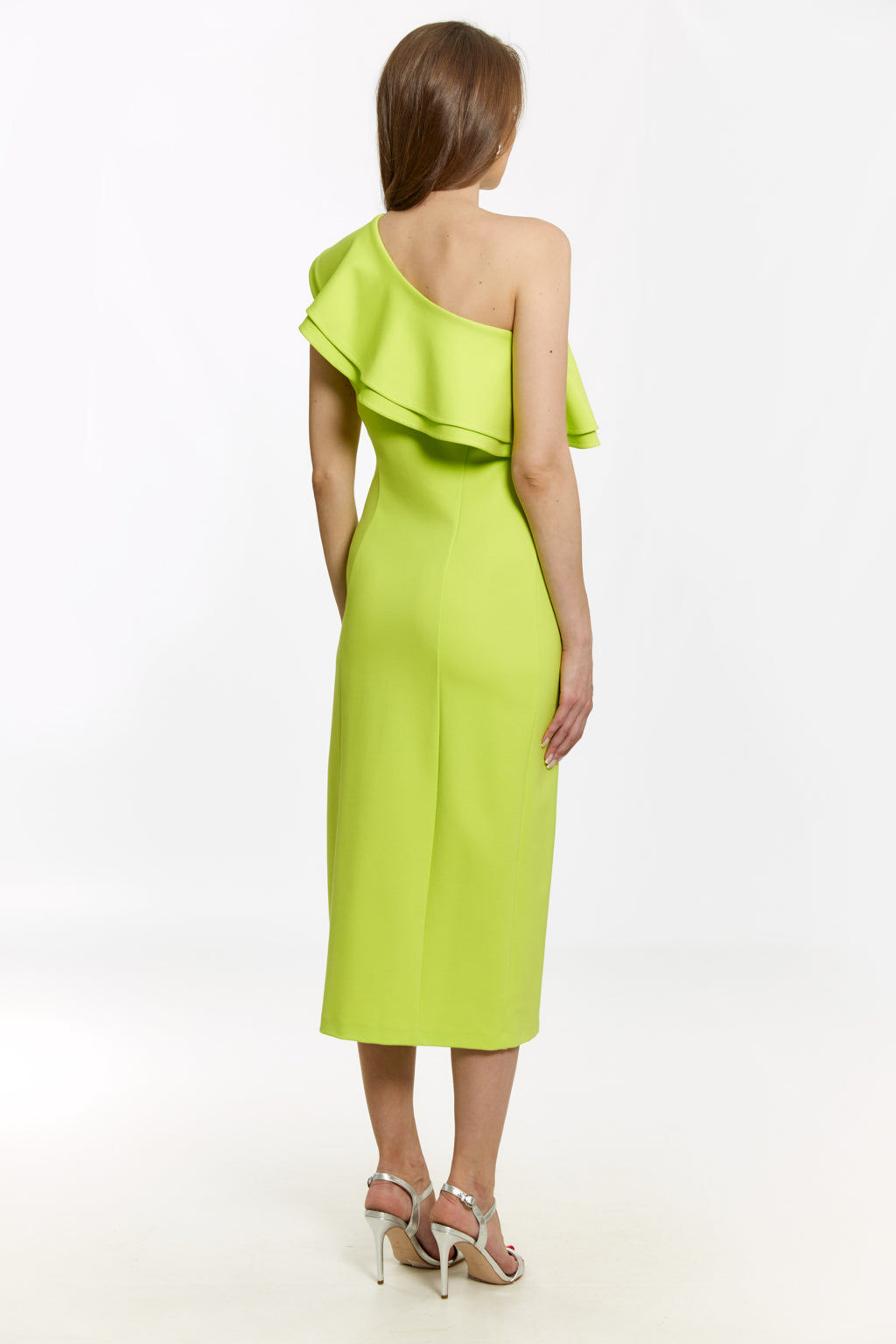 Woman wearing a bright green one-shoulder dress on a white background