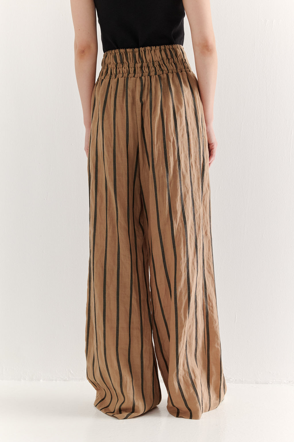 Person wearing brown striped pants on a white background