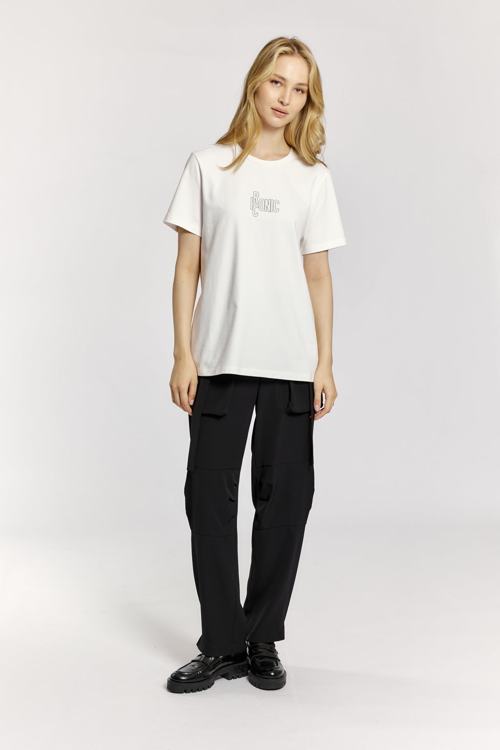 Person wearing a white t-shirt and black pants on a white background
