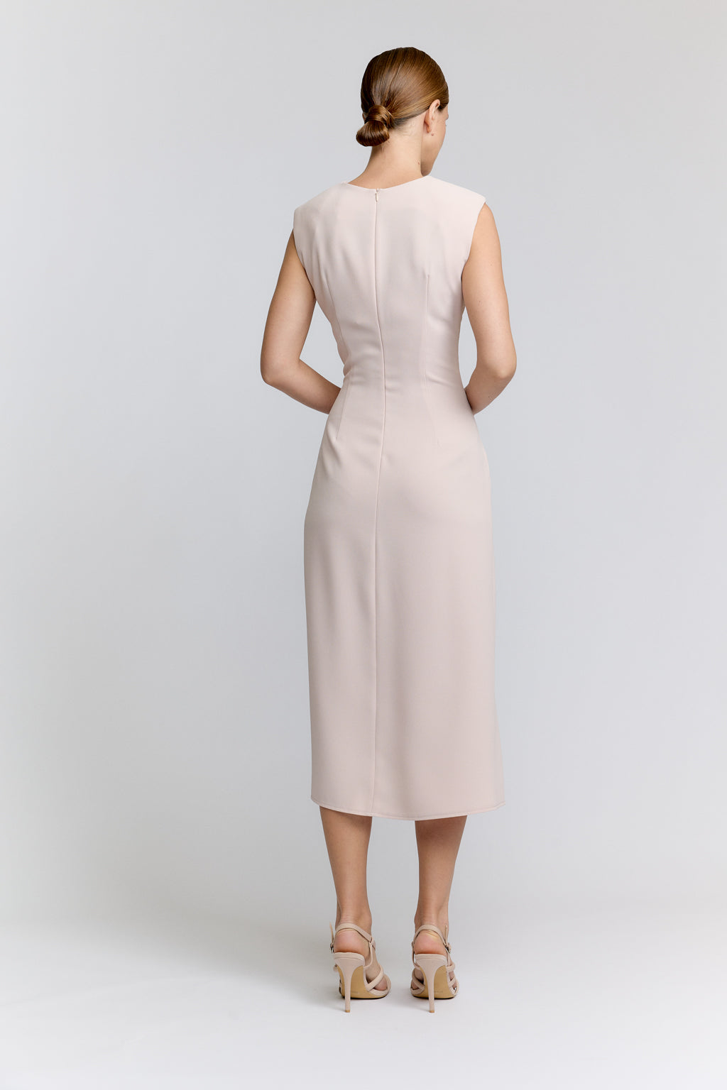 Woman wearing a beige dress on a white background