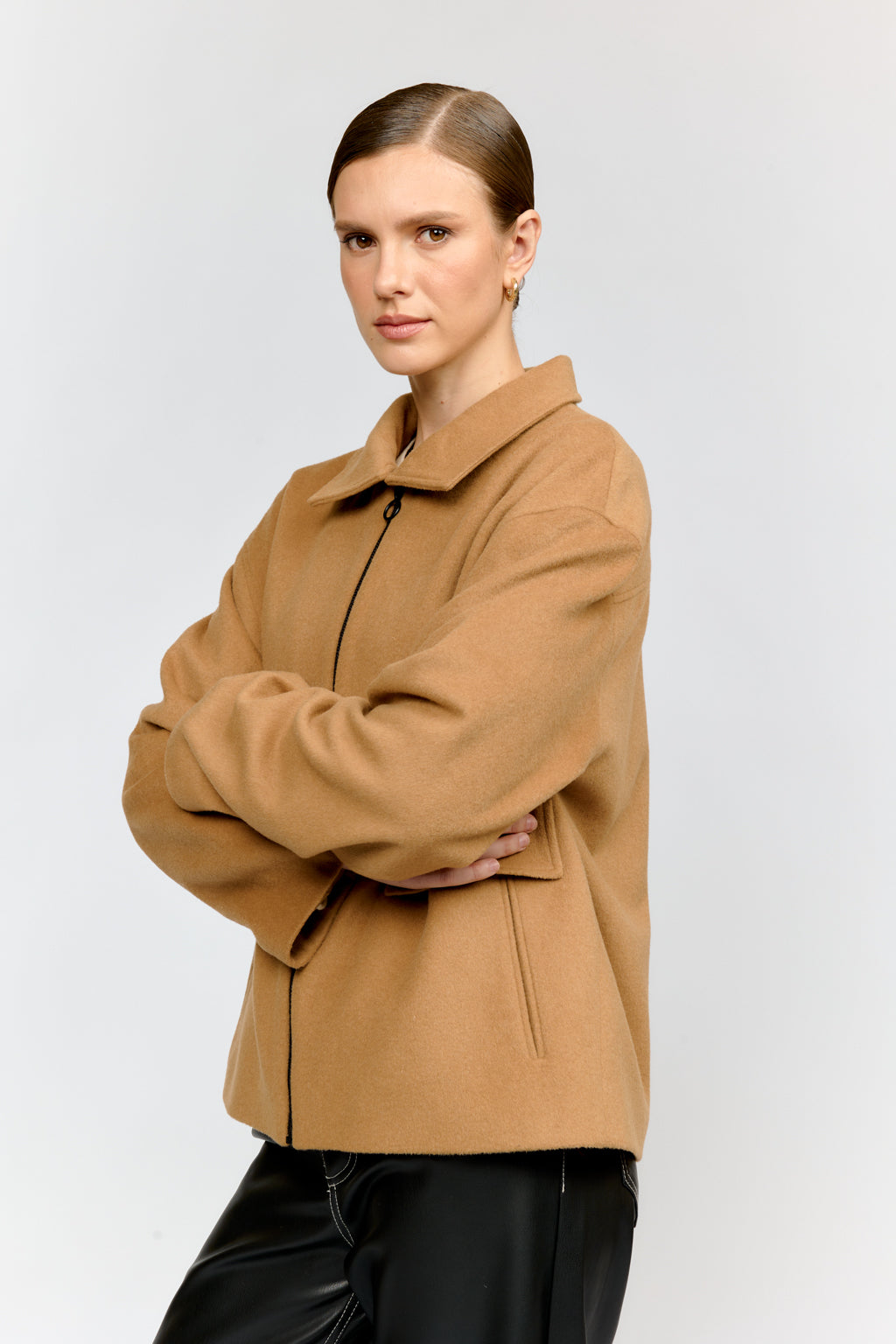 Woman wearing a brown coat against a white background