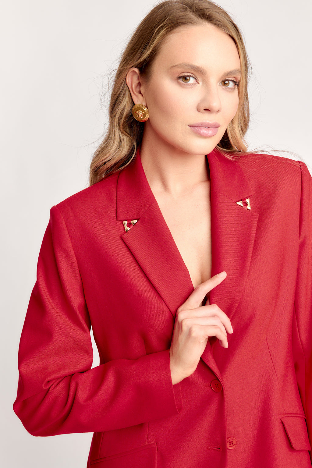 Woman wearing a red blazer with a plain background