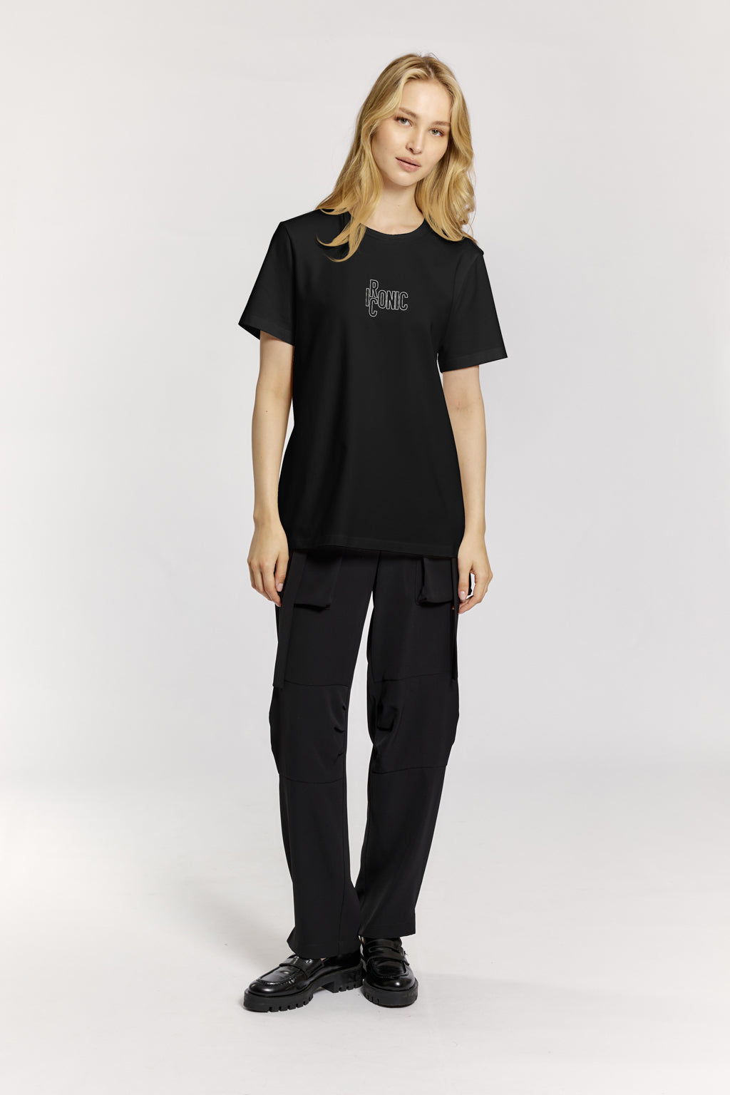 Person wearing a black t-shirt and pants on a white background