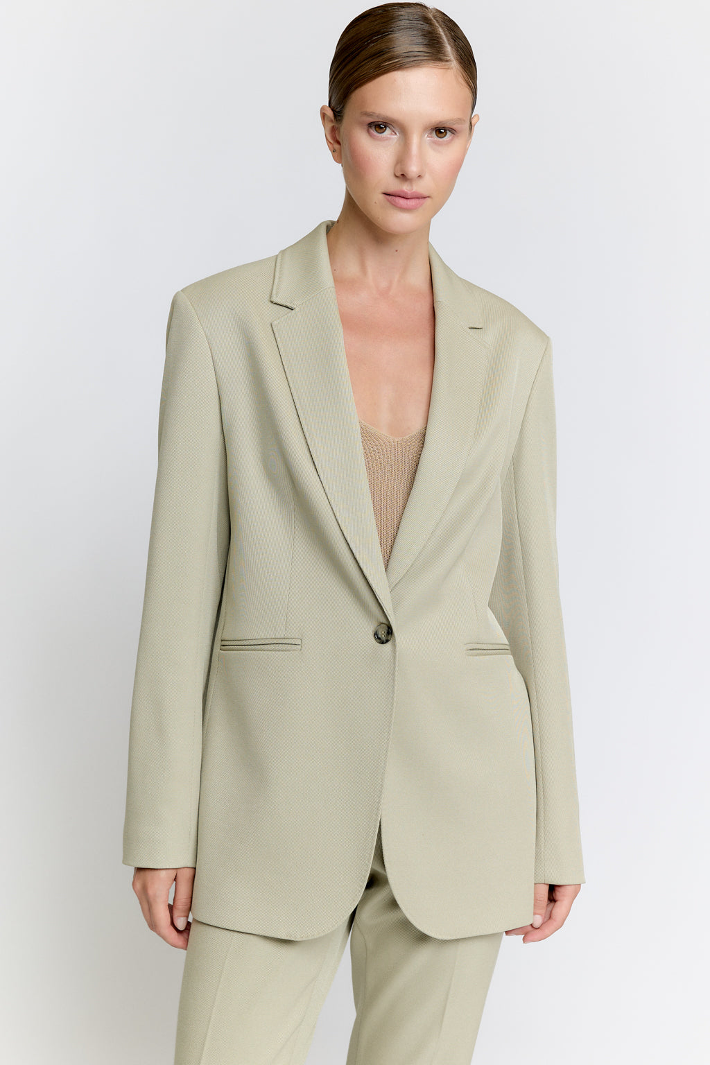 Woman wearing a light green suit on a white background