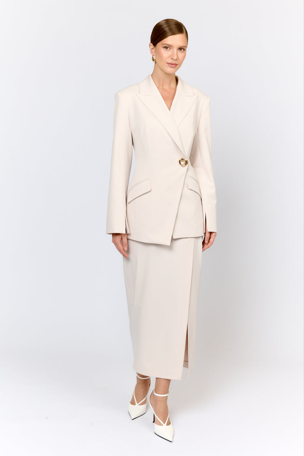 Woman wearing a beige suit with a white background