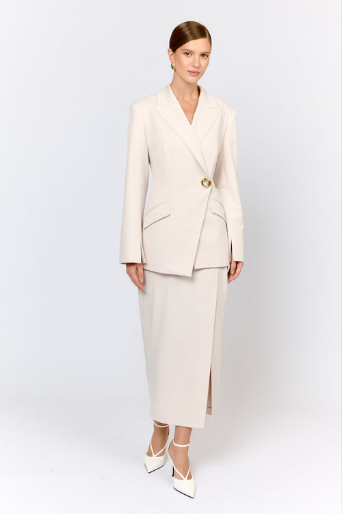 Woman wearing a beige suit with a white background