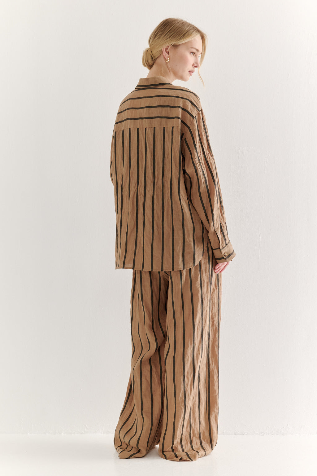 Woman wearing a brown striped outfit on a white background