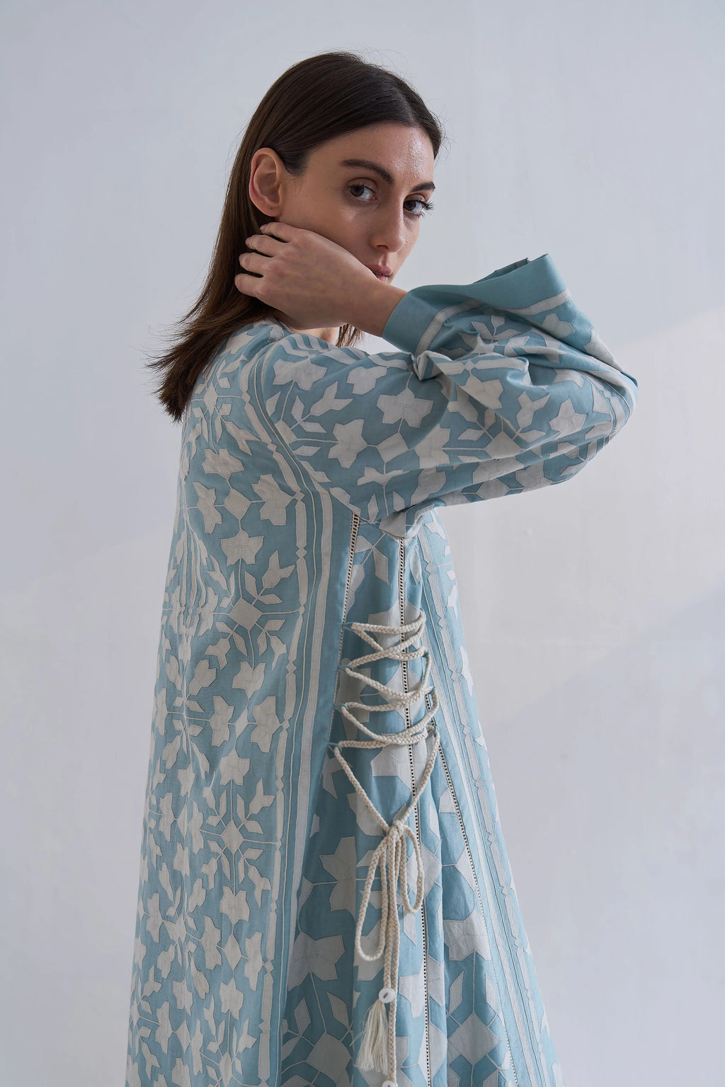 A floor-length cerulean blue Chanderi dress featuring ivory geometric hand-cut appliqué along the hemline and sleeves.