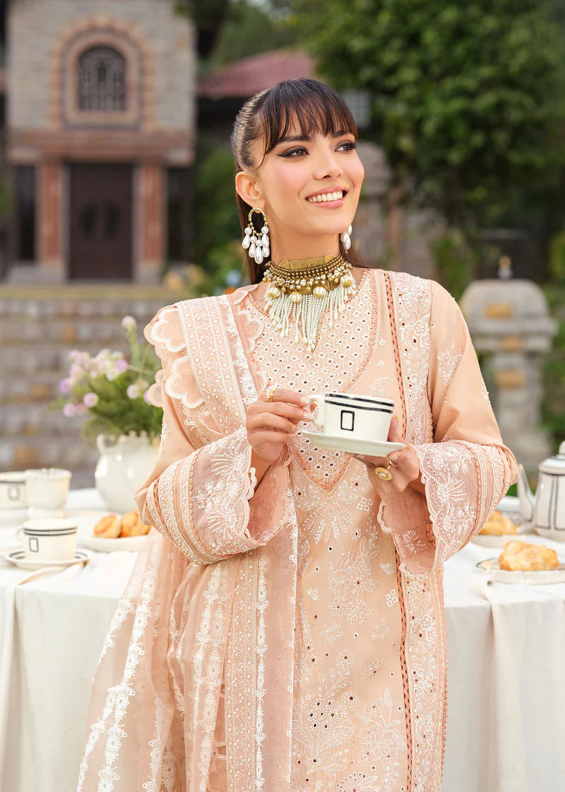 Woman in traditional attire holding a tea cup outdoors with a blurred background