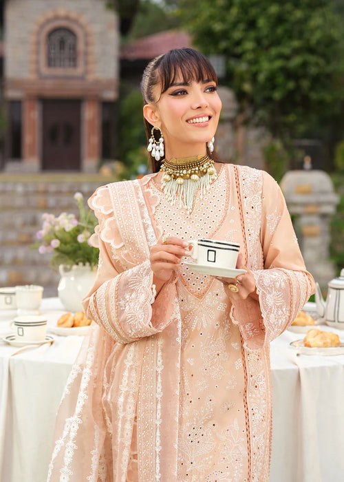 Woman in traditional attire holding a tea cup outdoors with a blurred background