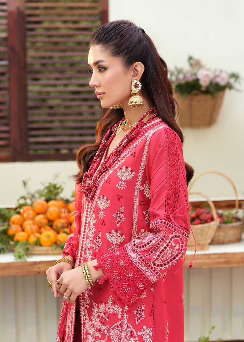 Woman in a red embroidered outfit standing outdoors with fruits and flowers in the background