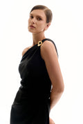 Woman wearing a black one-shoulder dress with a gold accent on a white background