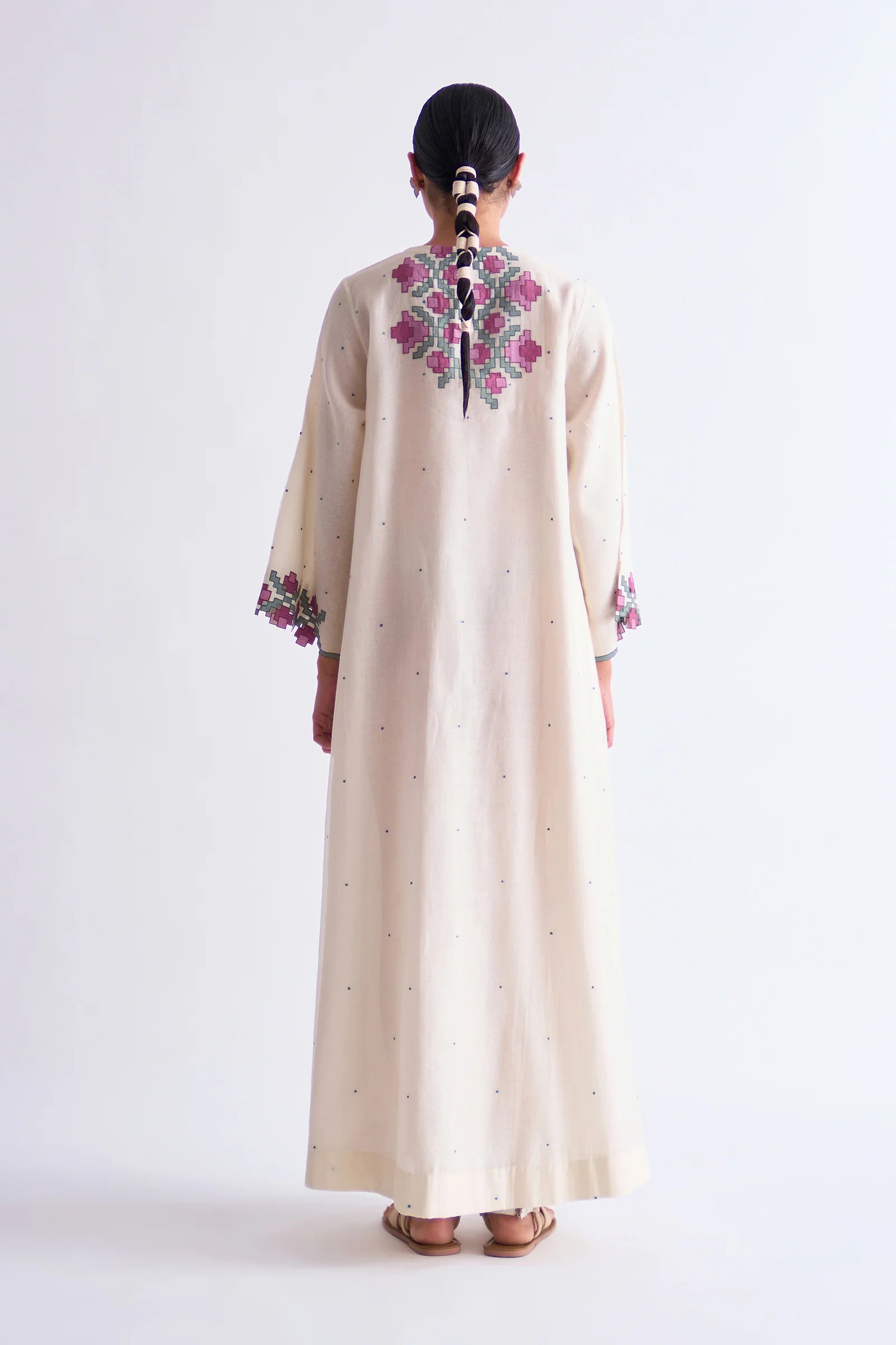 An ivory floor-length Cotton Silk Chanderi circular dress with soft pink geometric hand-cut appliqué panels on the bodice and sleeves.
