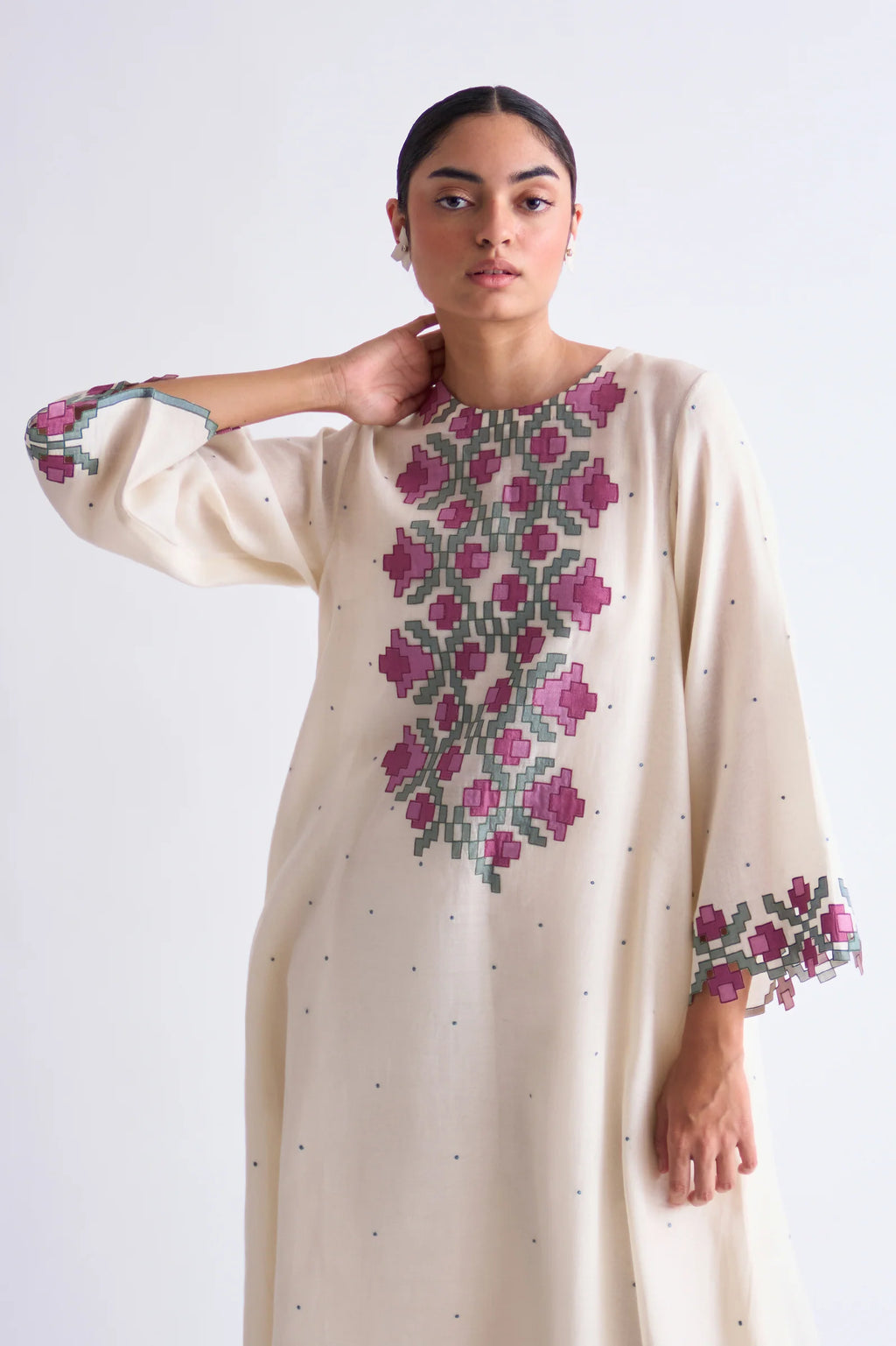 An ivory floor-length Cotton Silk Chanderi circular dress with soft pink geometric hand-cut appliqué panels on the bodice and sleeves.