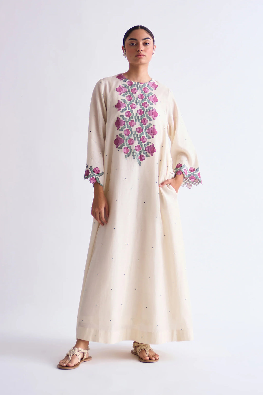 An ivory floor-length Cotton Silk Chanderi circular dress with soft pink geometric hand-cut appliqué panels on the bodice and sleeves.
