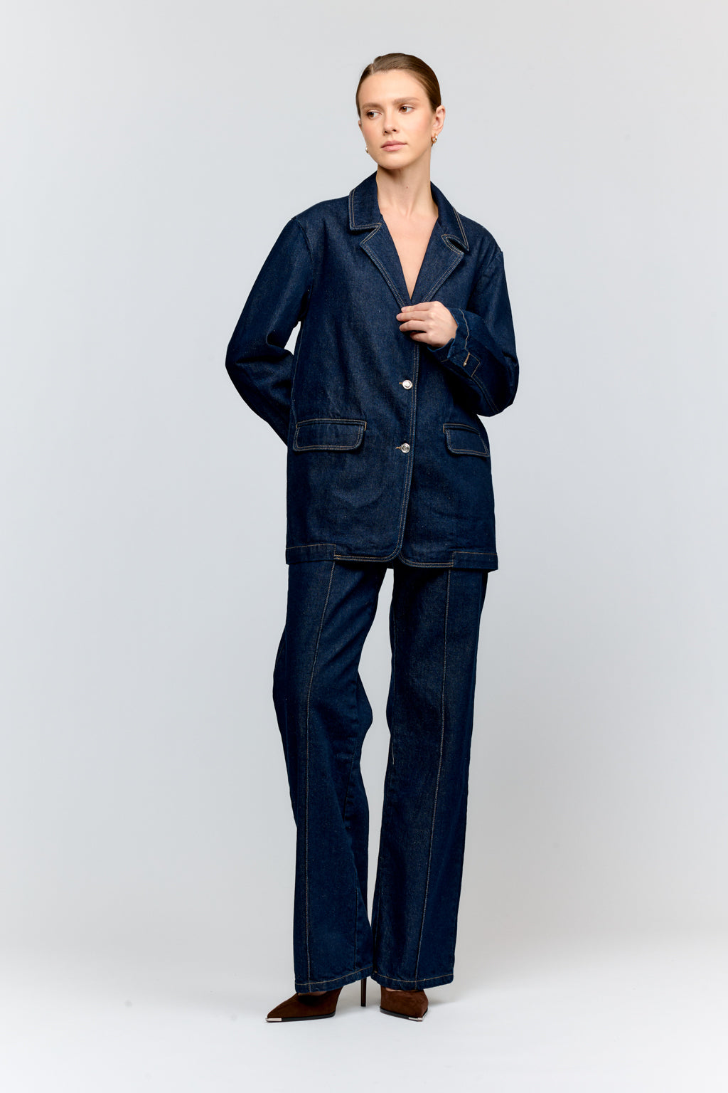 Person wearing a dark blue denim suit on a white background