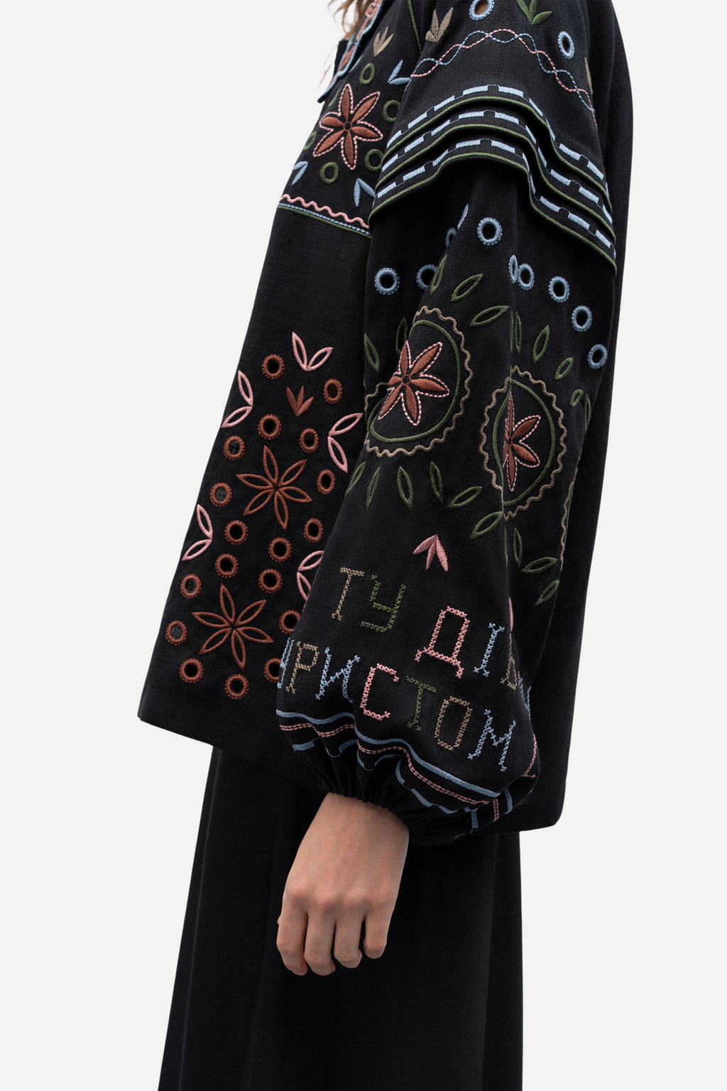 Black garment with colorful embroidery on a white background