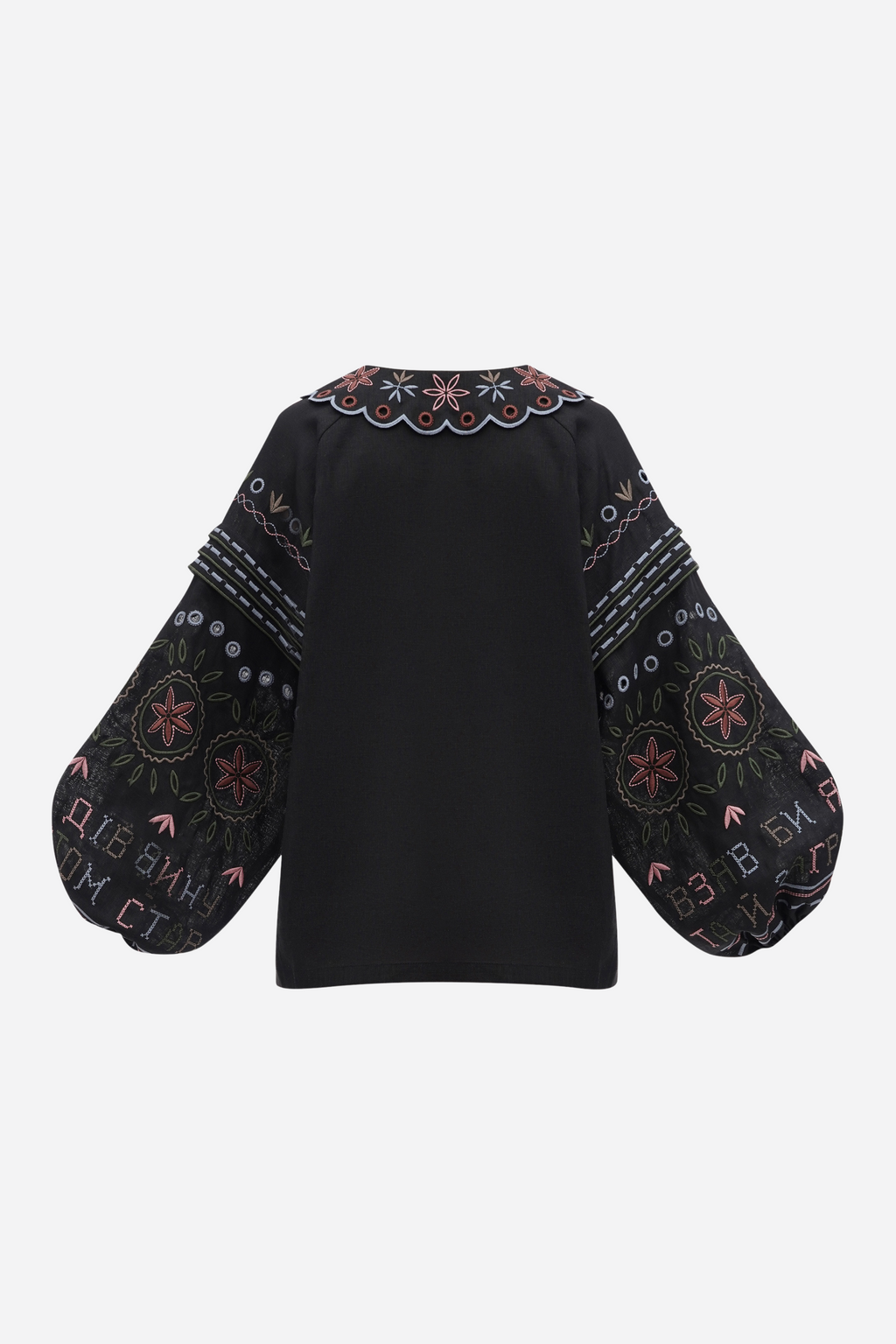 Black blouse with intricate embroidery on a white background