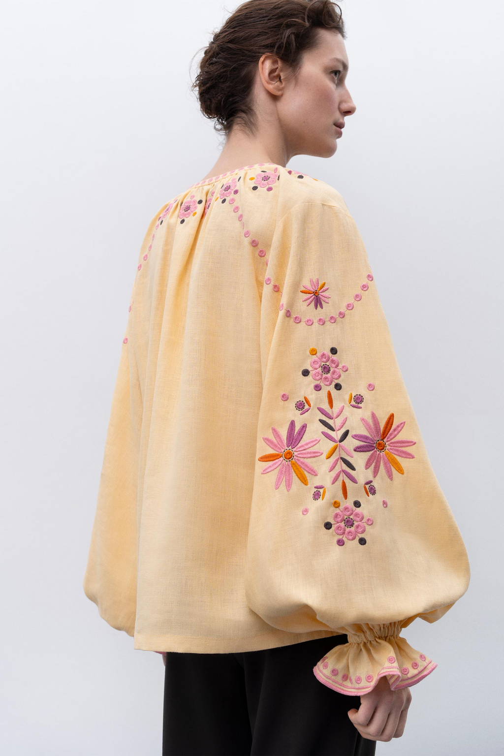 Light yellow garment with a decorative sleeve featuring black, white, and brown patterns.