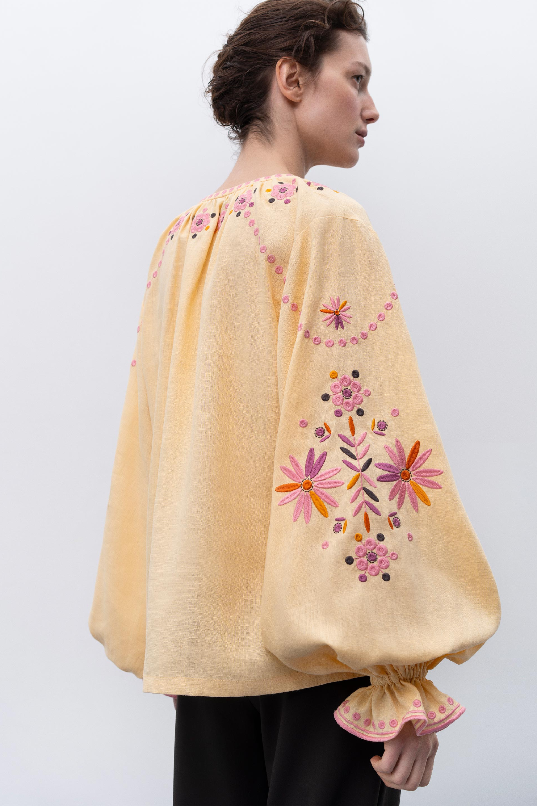 Light yellow garment with a decorative sleeve featuring black, white, and brown patterns.