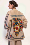 Woman wearing a beige jacket with colorful geometric patterns on a white background