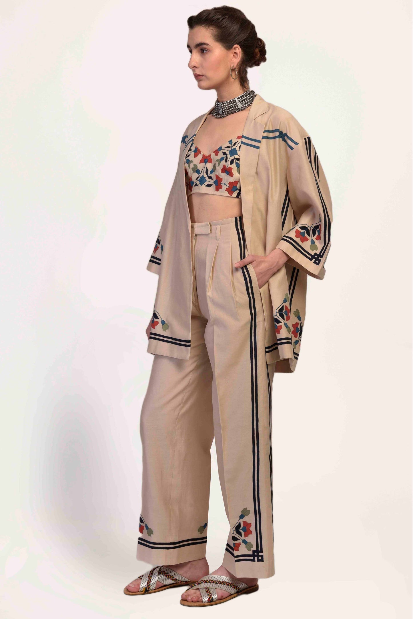 Woman wearing a beige outfit with floral patterns on a white background