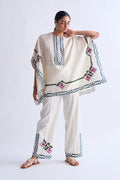 Woman wearing a traditional outfit with embroidery on a plain background