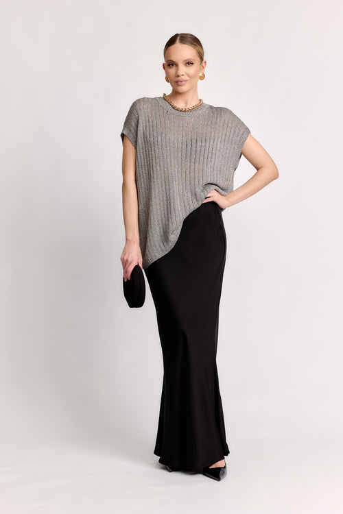 Woman wearing a gray top and black skirt on a white background