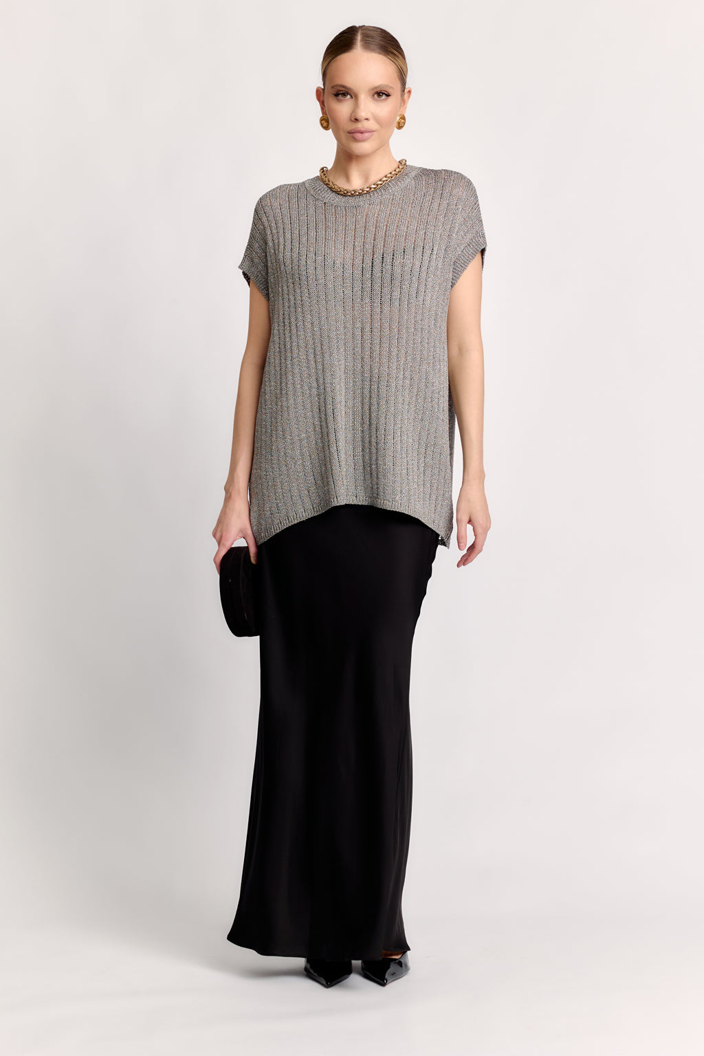 Woman wearing a gray ribbed t-shirt and black pants on a white background