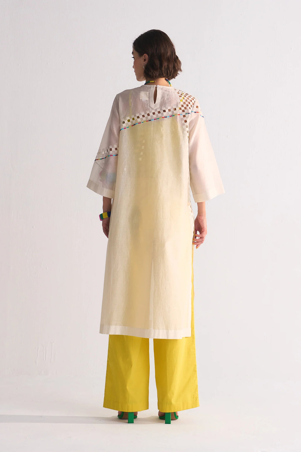 An ivory Cotton Silk Chanderi kameez featuring geometric cutwork on the shoulder and back, accented with multi-colored thread work and tonal appliqué.