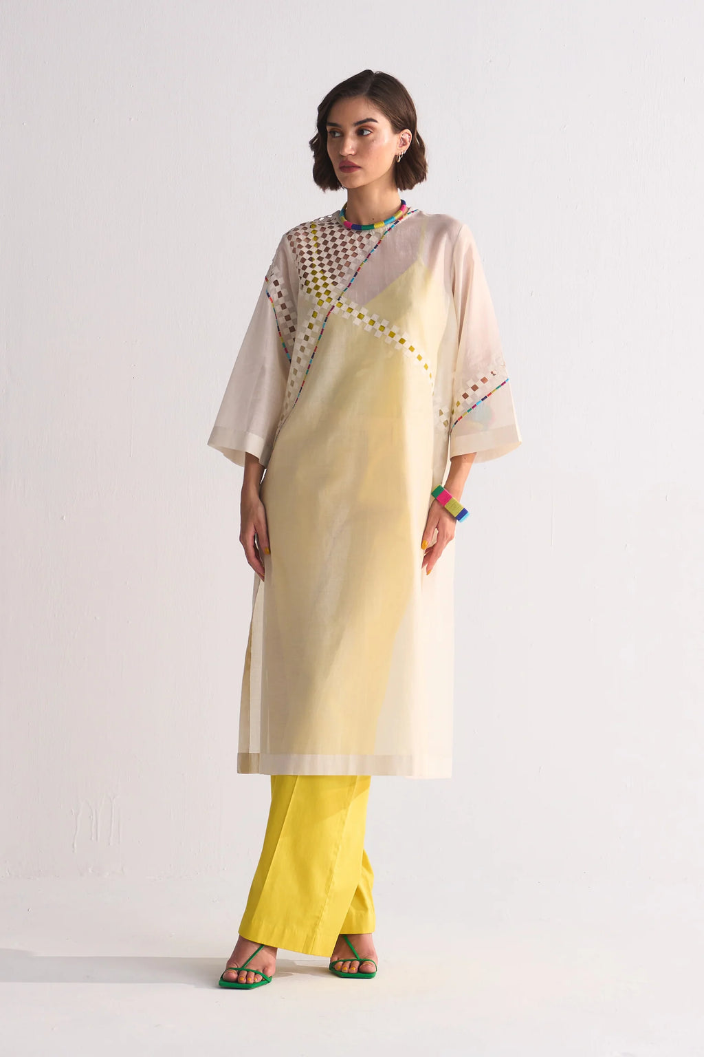 An ivory Cotton Silk Chanderi kameez featuring geometric cutwork on the shoulder and back, accented with multi-colored thread work and tonal appliqué.
