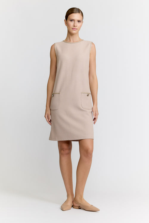 Woman wearing a beige sleeveless dress on a white background