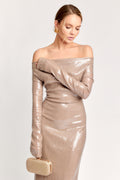 Woman wearing a metallic off-shoulder dress with a clutch on a white background